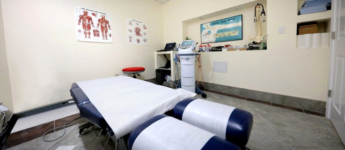 Treatment room with chiropractic table and therapy equipment